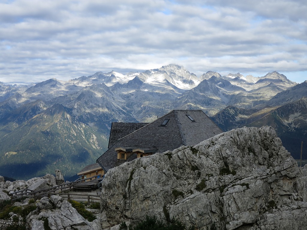 IMG_1588.JPG - Il rifugio Tuckett al mattino. Via recente che sale a destra della Sibilla. Ne siamo rimasti un po' delusi, roccia e tracciato non sono all'altezza delle classiche del Brenta. Per l'avvicinamento da Vallesinella salire al rifugio Tucket e da qui in pochi minuti alla evidente parete. Per l'attacco tenere come riferimento l'evidente diedro sbarratoda tetto. La via attacca a destra in un piccolo diedro, visibile chiodo con fettuccia a 3 o 4 m da terra. Preciso il tracciato della relazione, fare comunque attenzione sui tiri 'facili' perchè le difficoltà sembrano superiori a quanto riportato e la roccia e spesso coperta di detrito.  In discesa è consigliabile restare legati sulla cengia e rinviare i numerosi anelli con moschettoni presenti.